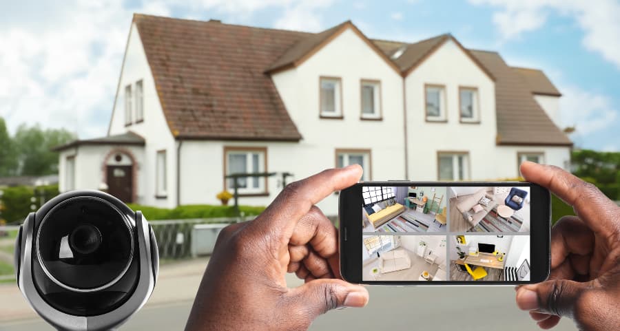 Man holding smartphone and viewing footage from surveillance cameras